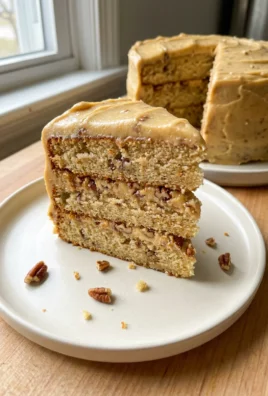Close-up of the side of a butter pecan cake showing the fluffy frosting.