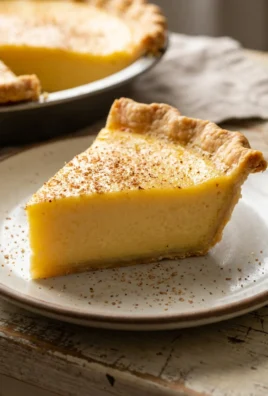 A slice of egg custard pie on a white plate, with a fork nearby.