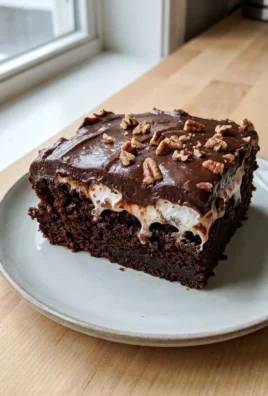 A fork taking a bite out of a piece of Mississippi mud cake on a plate.